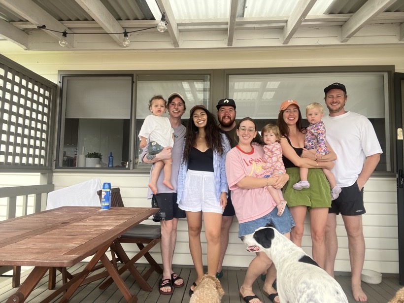 Brittany and loved ones gathered on a sunny deck with children and dogs.